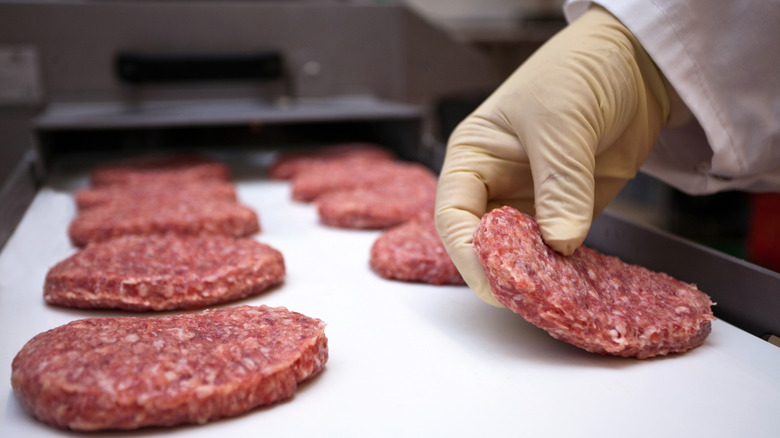 Raw Beef Patties Lined on Baking Sheet