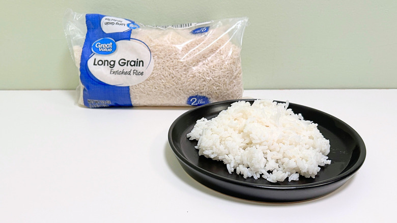 A bag of Great Value Long Grain Rice next to a black plate of rice