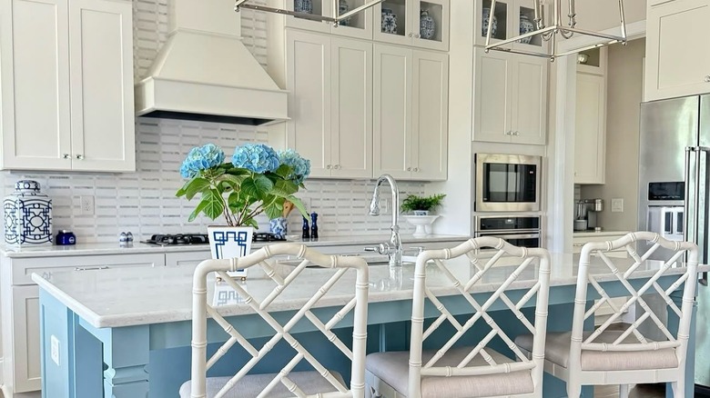 A  large, traditional kitchen with white cabinets and a large blue-painted island