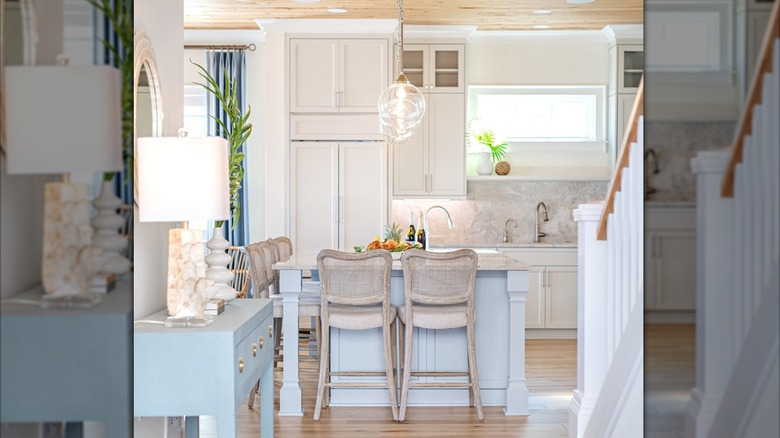 A kitchen with white cabinets and blue accents, with wooden floor and ceiling