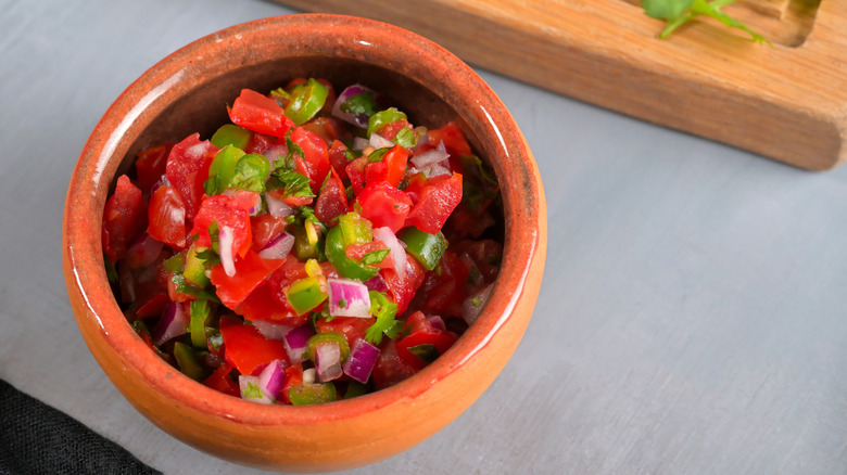 A small clay bowl of pico de gallo