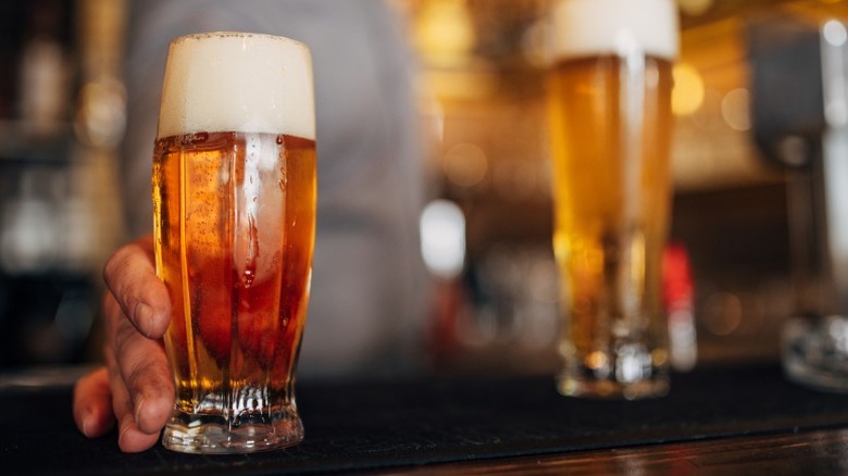 A close up of a bartender serving a beer