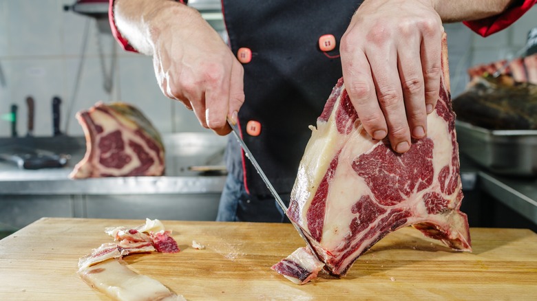 A chef butchers a large piece of beef