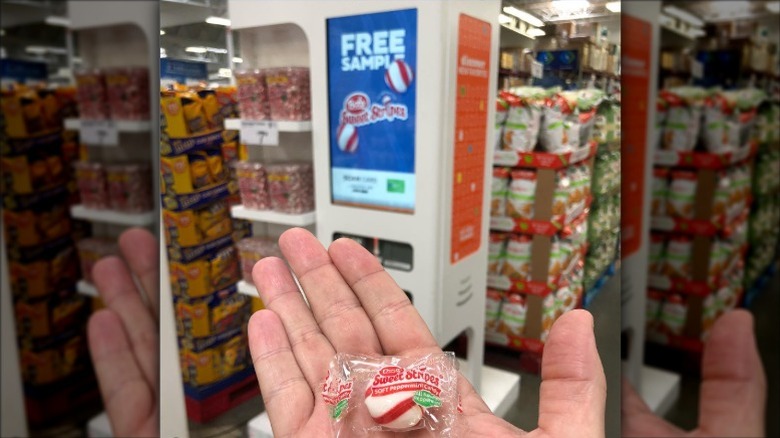 A close up of a sweet candy in front of a slightly blurred Freeosk machine