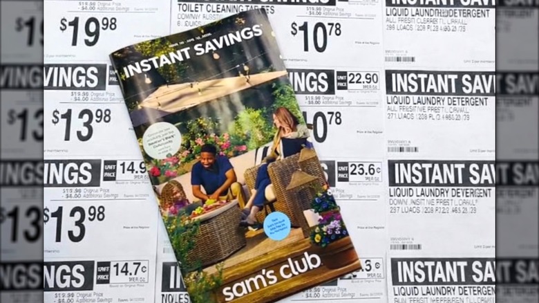 A booklet of Sam's Club Instant Savings on top of Instant Savings store signs
