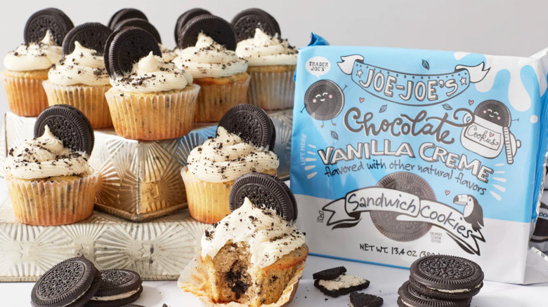 A display of cupcakes with Oreo cookies inside them next to a package of Chocolate Vanilla Creme Joe-Joe's Sandwich Cookies