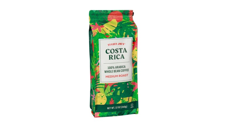 A bag of Costa Rica Whole Bean Coffee, with a green, yellow, and red tropical leaf pattern