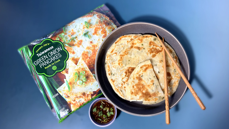 Package and dish of green onion pancakes with dipping sauce and chopsticks