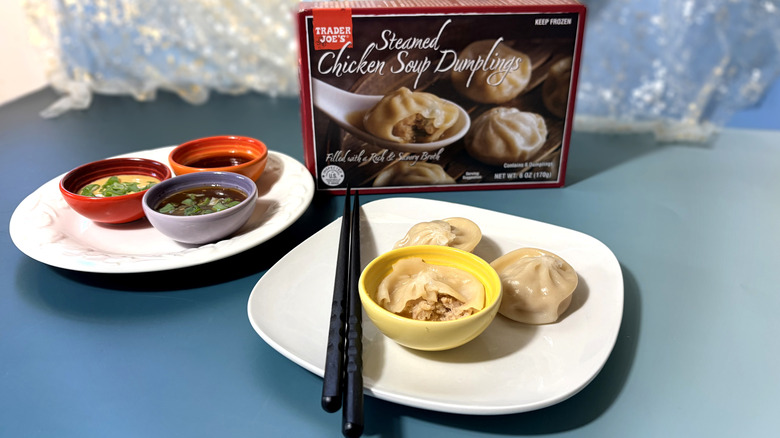 package and plate of chicken soup dumplings with chopsticks and dipping sauces