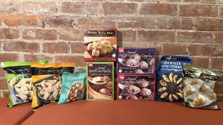 An assortment of Trader Joe's frozen dumplings against a brick wall