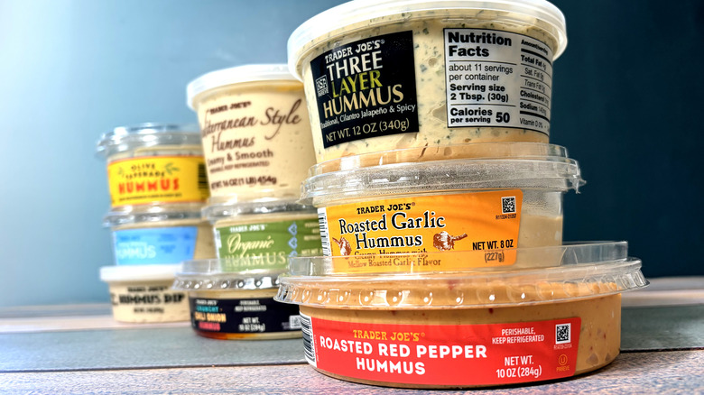Stacked containers of Trader Joe's hummus varieties