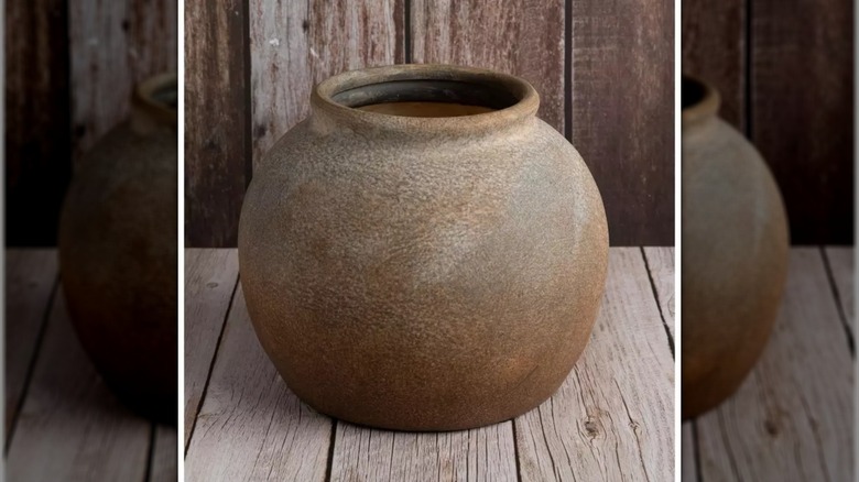round distressed vase on wood surface