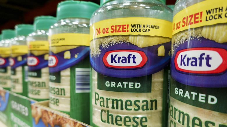 Containers of Kraft grated Parmesan cheese on a store shelf