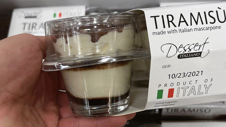 Hand holding an individual tiramasù dessert cup from Costco