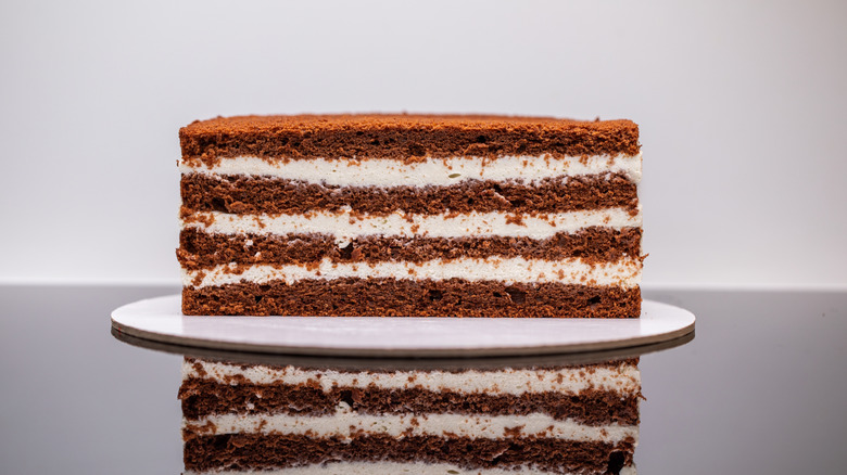 A chocolate cake with buttercream sliced down the middle, exposing the layers inside