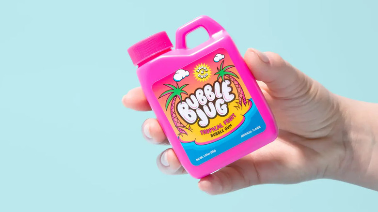 A hand holding a small container of Hubba Bubba Bubble Gum shaped like a detergent bottle.
