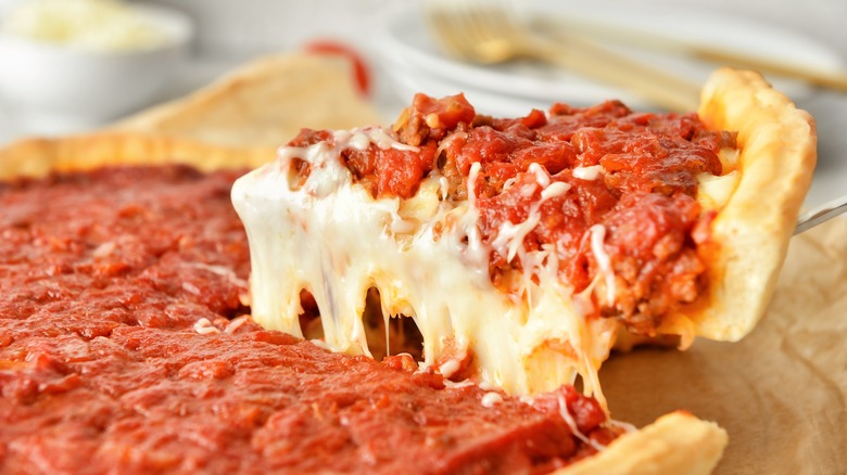 slice being served from deep-dish pizza