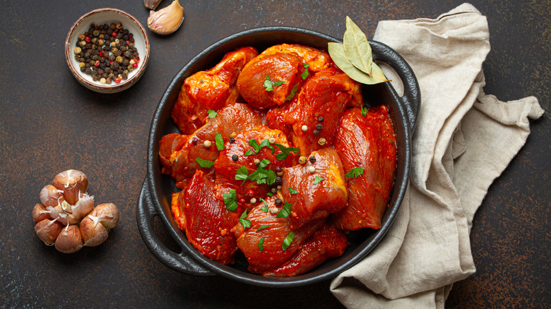 marinating raw chicken breast with garlic and peppercorns