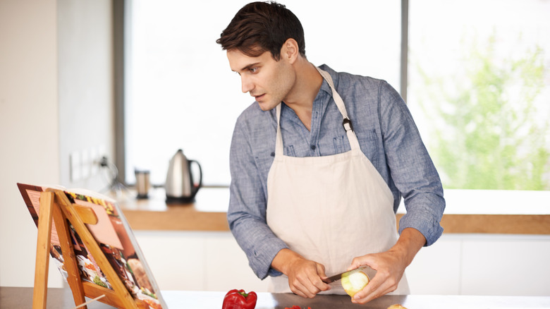 Man preparing a meal from a recipe