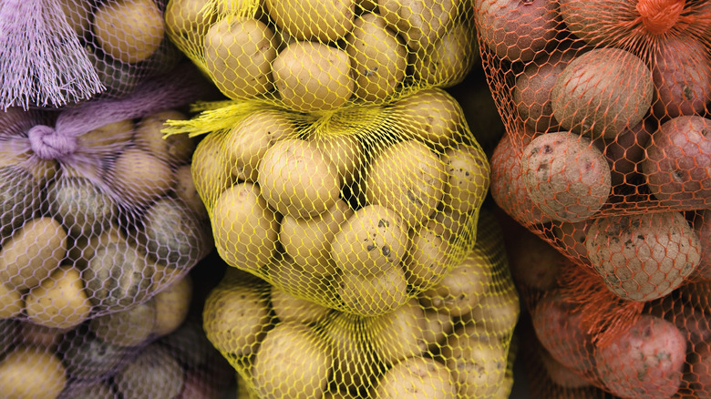 Purple, gold and red potatoes in bags