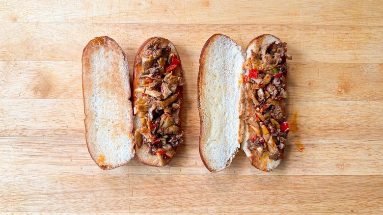 Toasted pretzel hoagie buns with oyster mushroom and chili relish on cutting board