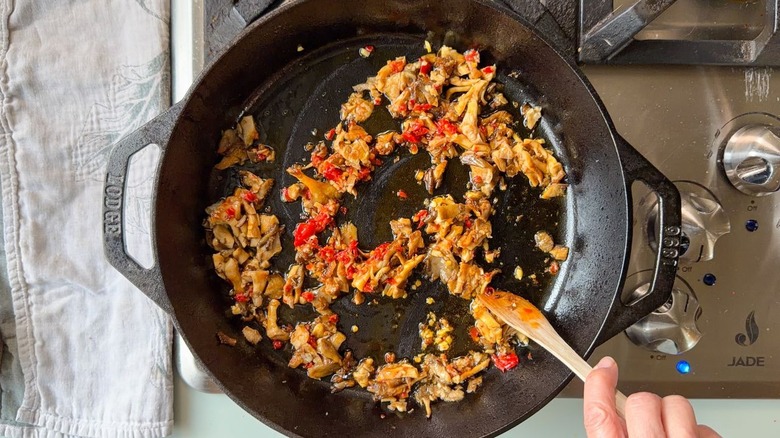 Stirring mushroom and chile paste mixture in skillet