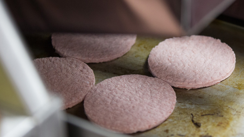 frozen hamburger patties on grill