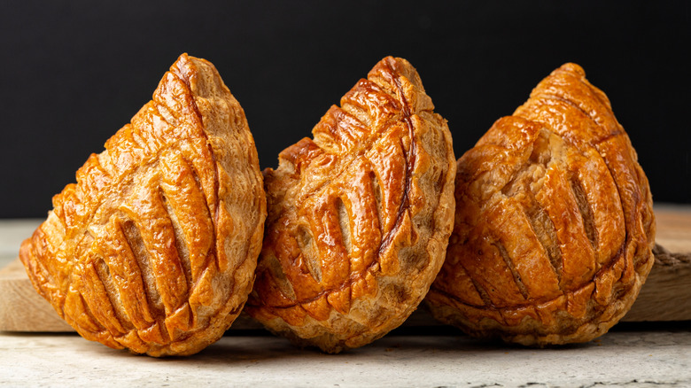 Baked pastries on wooden surfaces against dark background