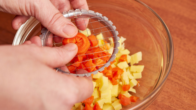 Man chopping potatoes and carrots for ensalada rusa