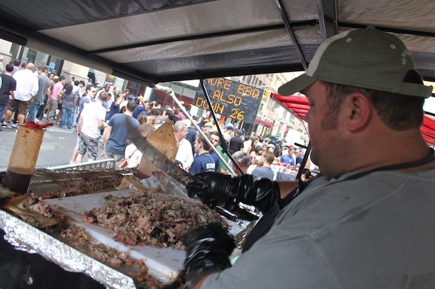 Ken from Big Bob Gibsons chops pork for pulled pork sandwiches. 