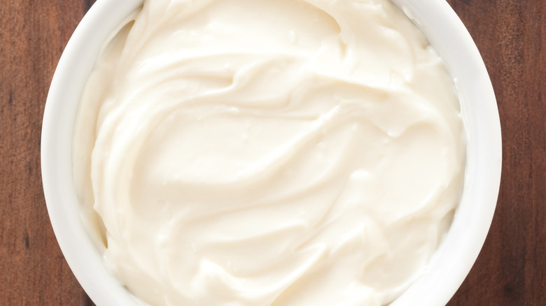 Cream cheese in white bowl on wood