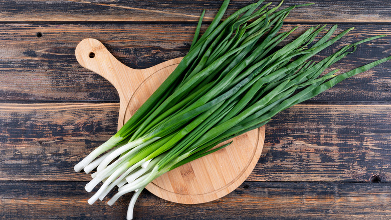 Scallions on wood cutting board