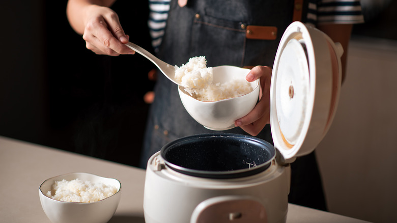 Person scooping rice out of pot