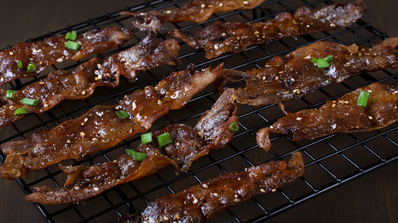 Millionaire's bacon on rack topped with scallions.