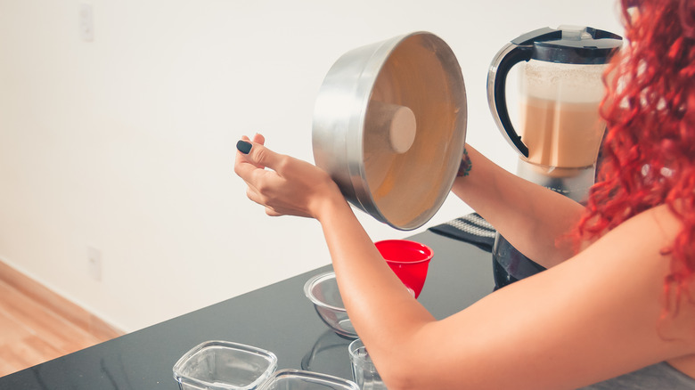 A red haired woman making a cake in a metal tin