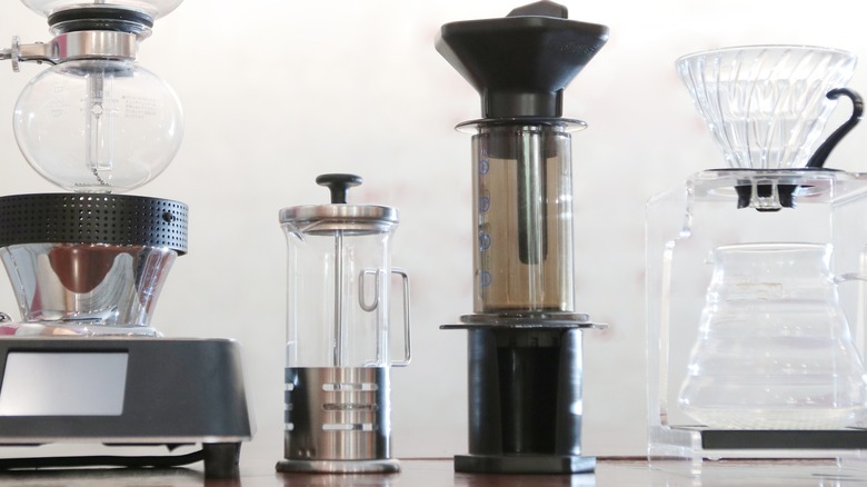 4 coffeemakers including a French press and AeroPress lined up on a counter