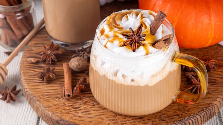 Pumpkin spice latte with cinnamon sticks in glass mug