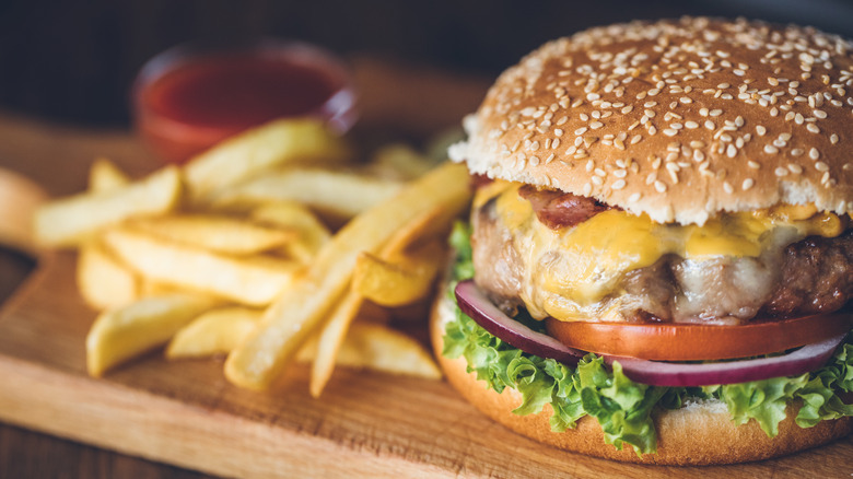 Burger and fries on wooden board