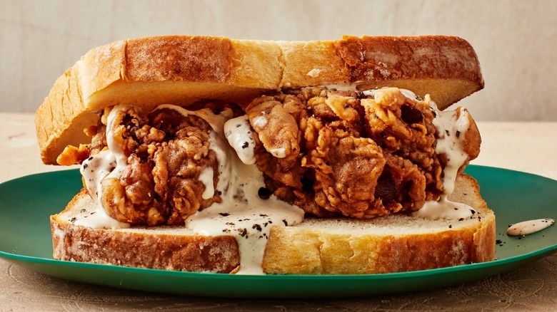 Fried chicken sandwich covered in white barbecue sauce