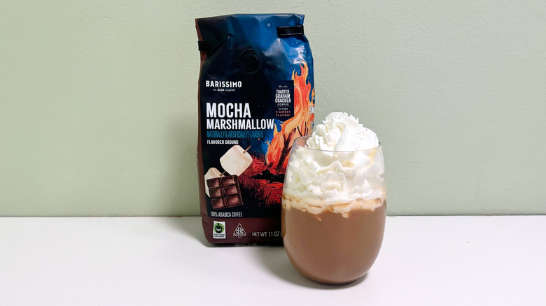 A bag of Barissimo Mocha Marshmallow Coffee next to a cup of coffee with whipped cream