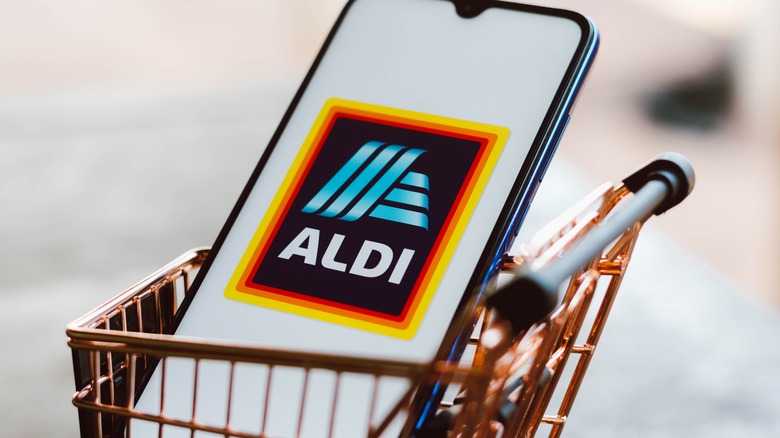 Aldi logo on smartphone in small shopping cart