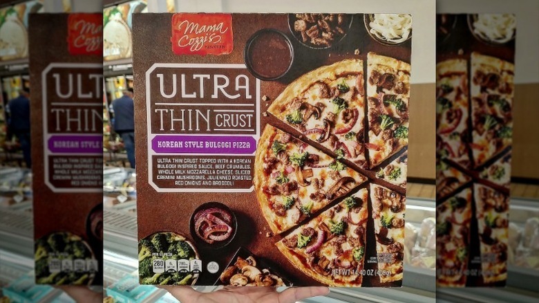 Hand holds Aldi's Korean pizza box