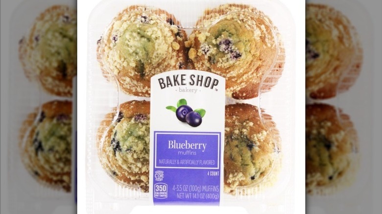 a four-pack of large blueberry muffins against a white background.