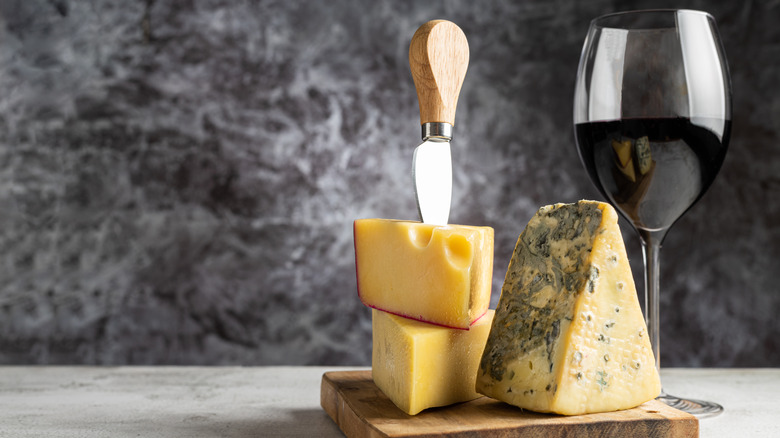 Cheese with knife and glass of wine