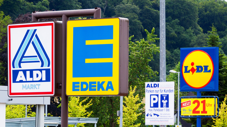 Aldi and Lidl store signs in Germany with a forest in the background