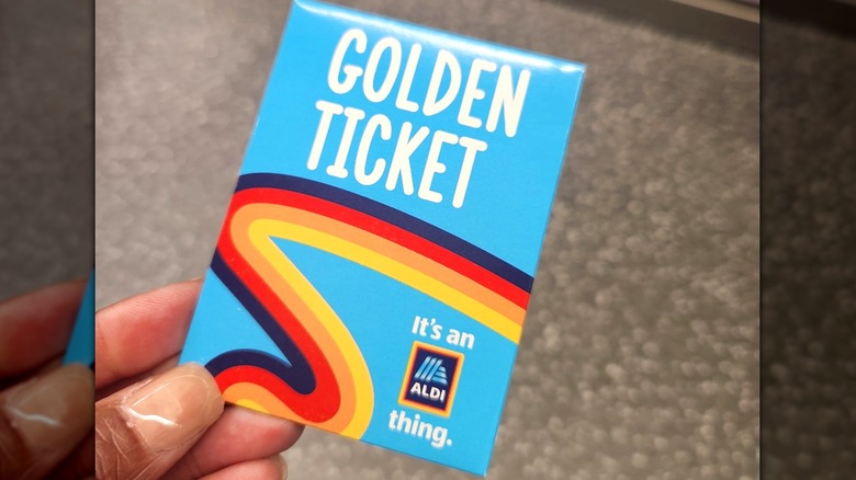 A person holds an Aldi Golden Ticket inside the store