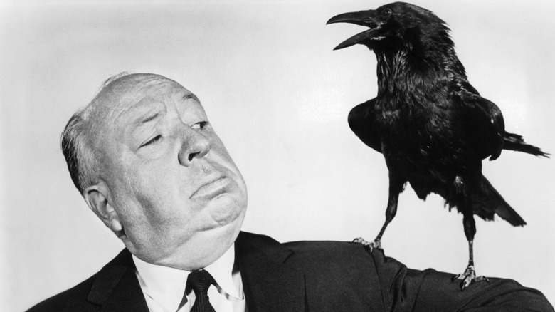 Alfred Hitchcock looking at black crow