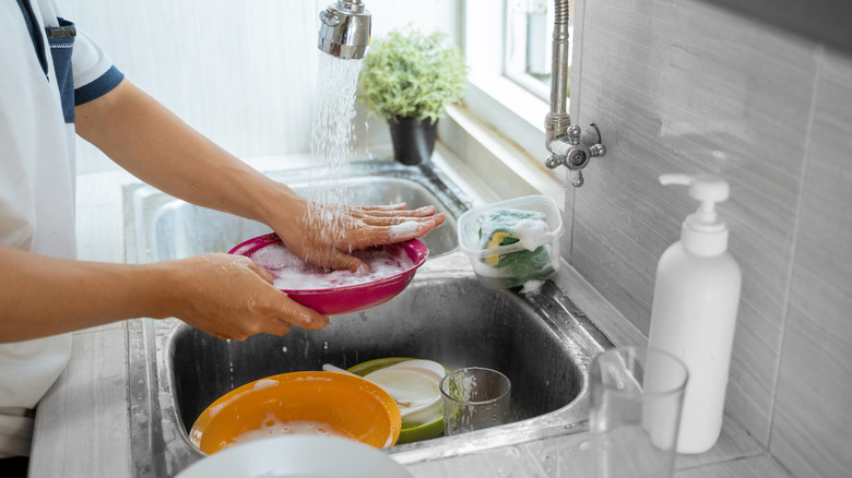 person washing dirty dishes 