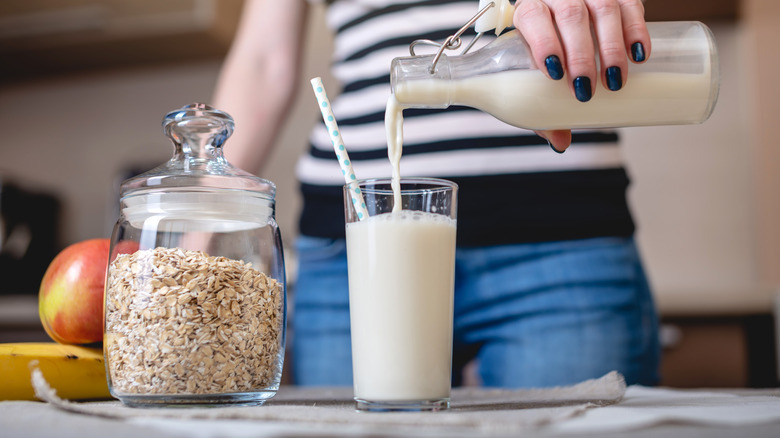 pouring oat milk into glass