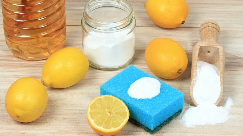 lemons salt and sponge on wooden counter